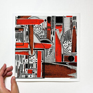 This image depicts a hand holding an abstract artwork. The artwork features a geometric composition with bold red, black, and white shapes, lines, and patterns. The design includes various rectangles, circles, and curved forms, creating a dynamic and intricate visual effect. The red elements stand out against the black and white, giving the piece a strong contrast. The image is set against a plain white background.